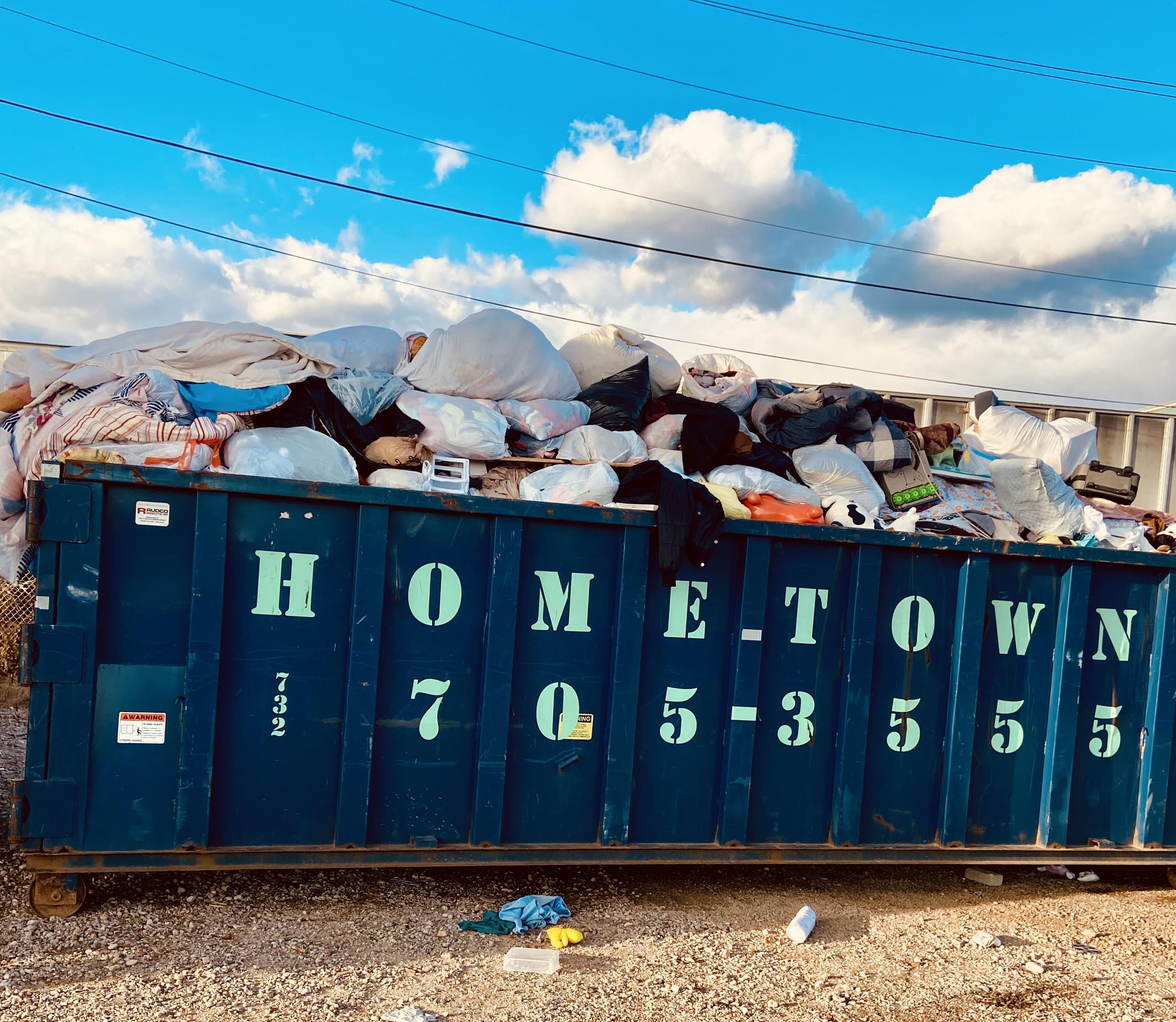 a dumpster overflowing with random household objects
