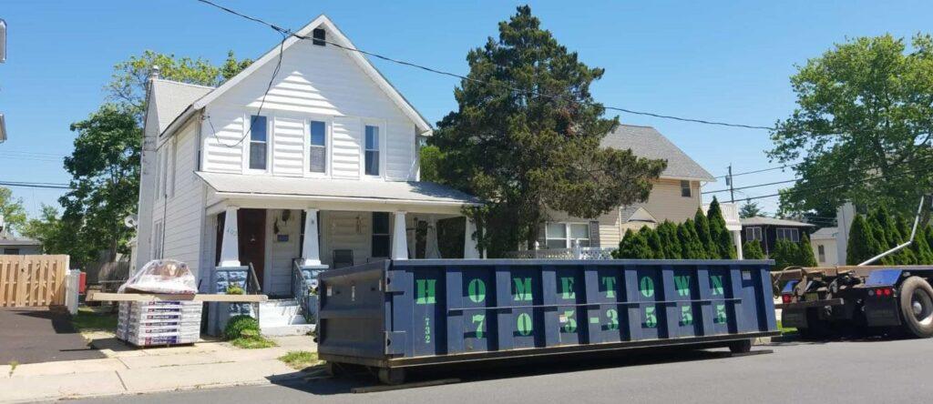 hometown-waste-dumpster-on-wood-planks-for-roofing-job